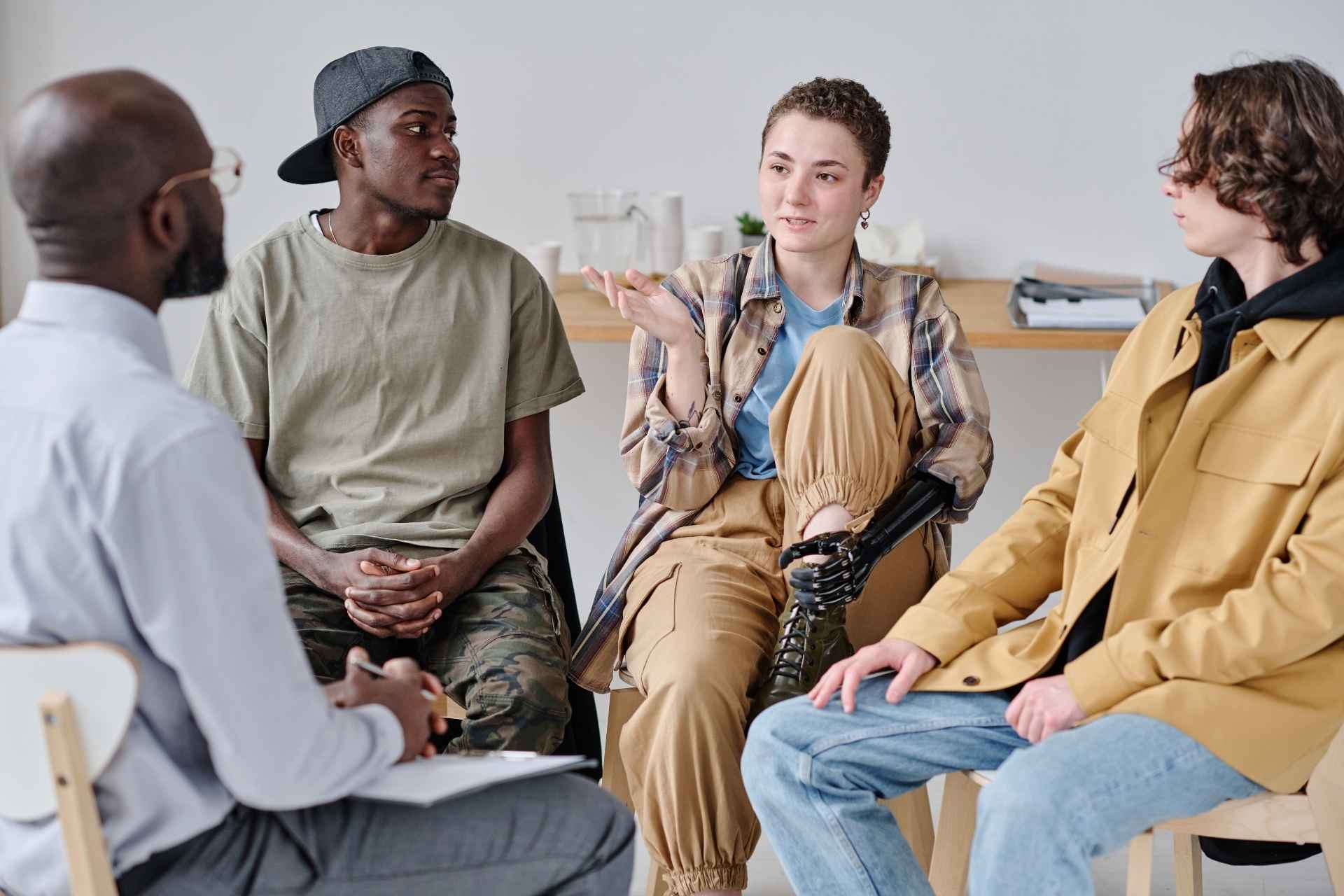 Young adults discussing substance use recovery during an addiction treatment group