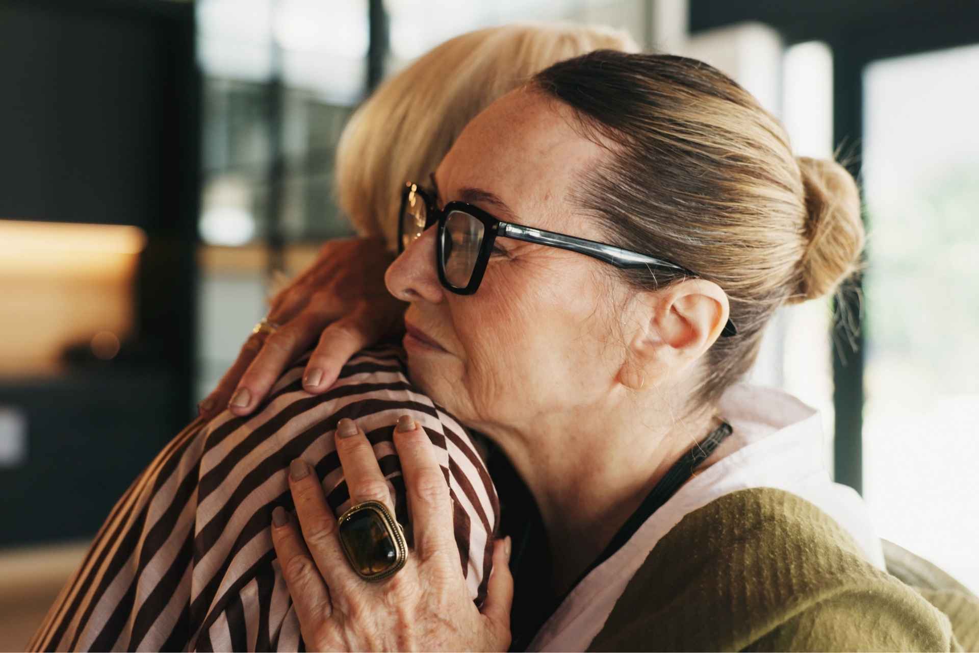 Two women embracing while supporting each other during addiction recovery