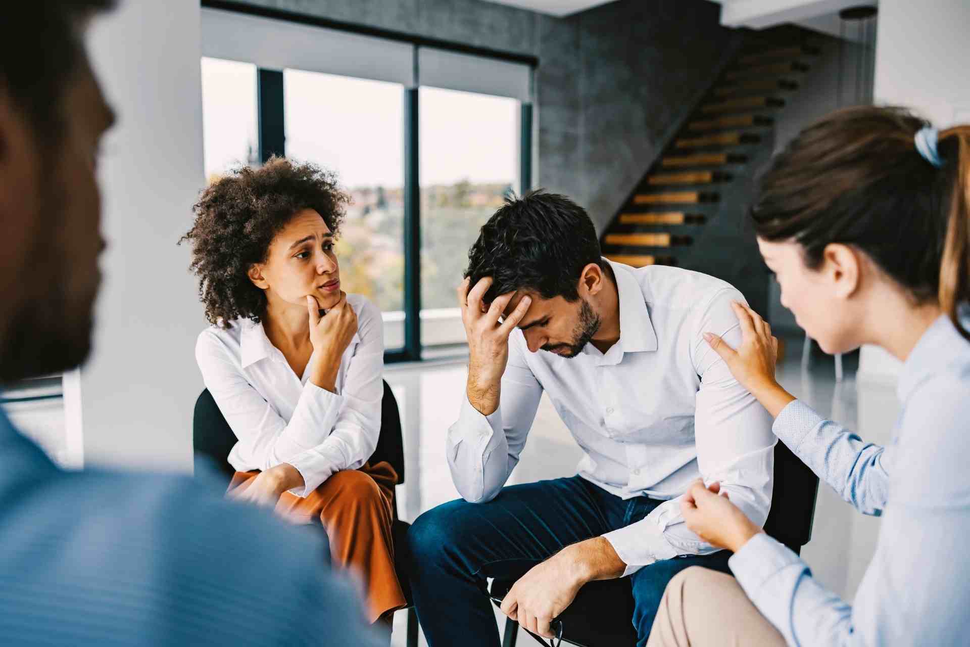 People participating in supportive group therapy session for addiction recovery