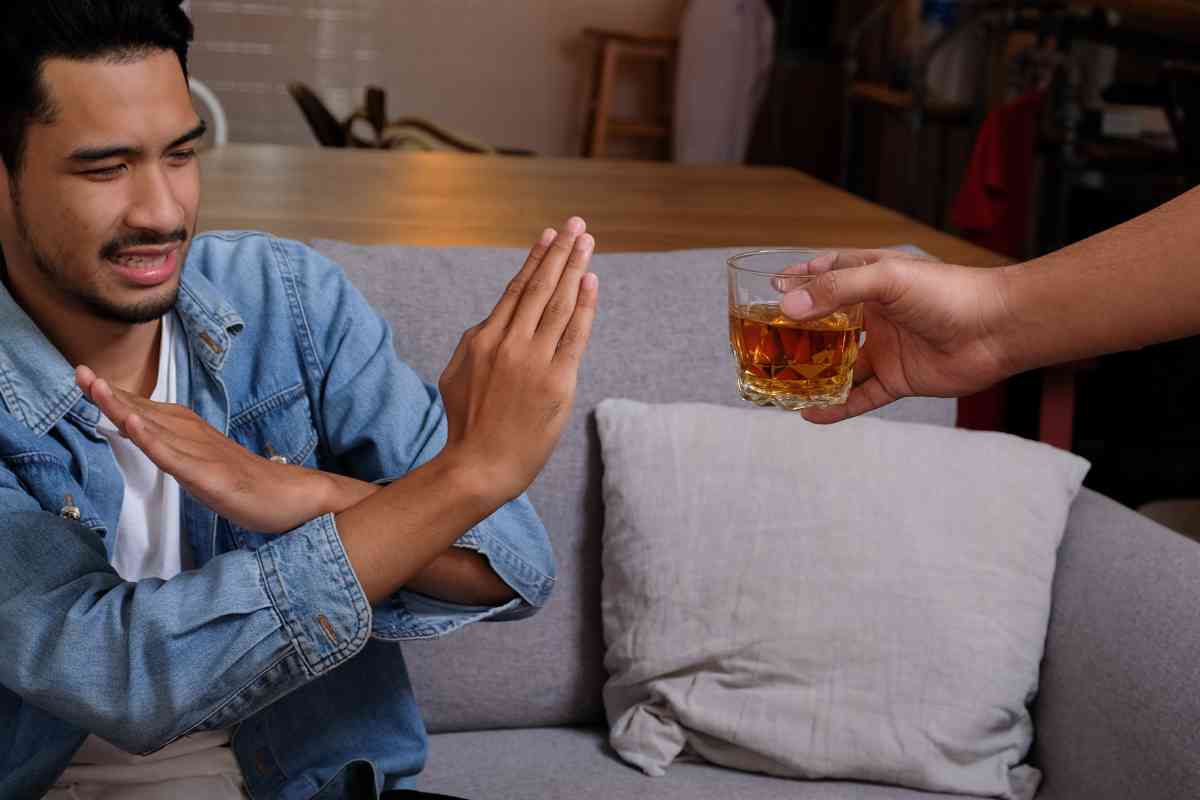 Person refusing an alcoholic drink as part of alcohol recovery and quitting drinking safely